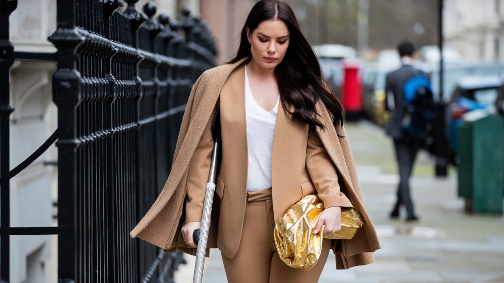 woman dressed in brown wearing brown cape over her shoulders, a fashion trend that isn't worth the money