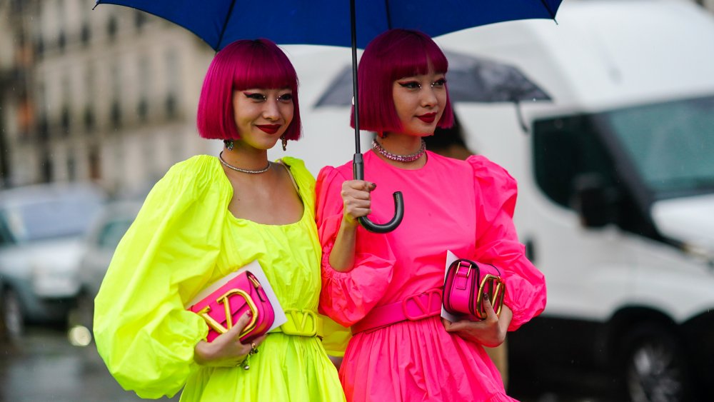 Women with pink hair wearing neon dresses, a fashion trend that isn't worth the money