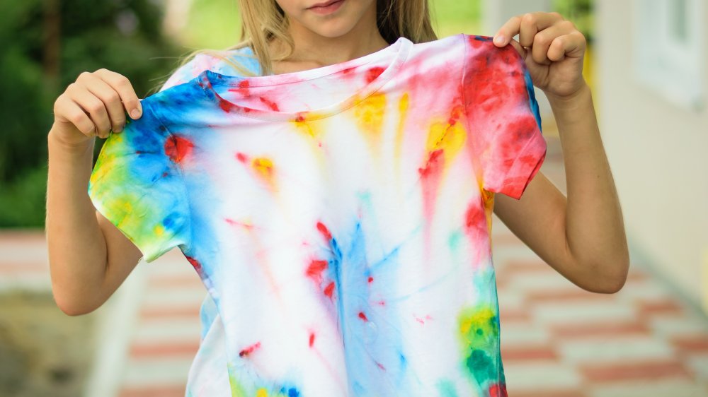 woman holding tie dye shirt, a fashion trend that isn't worth the money
