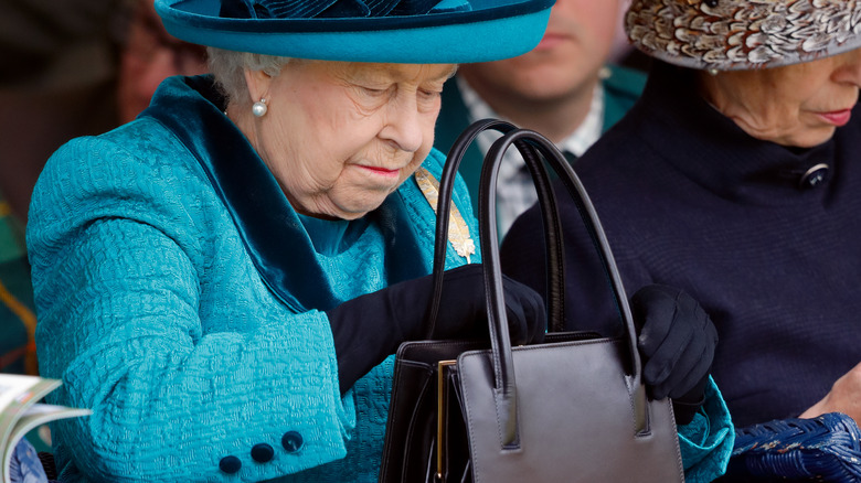 Queen Elizabeth looking in purse