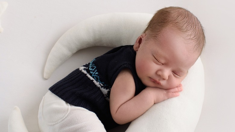 Baby sleeping on a moon-shaped pillow