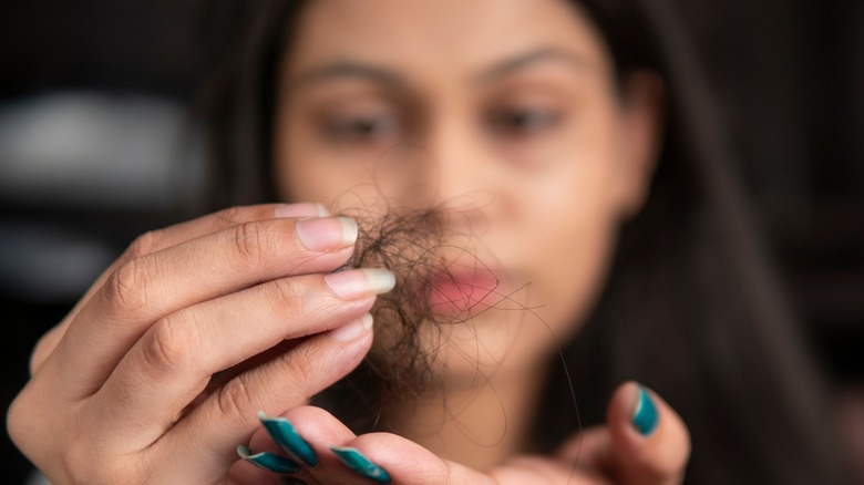 A woman with her shed hair in hand