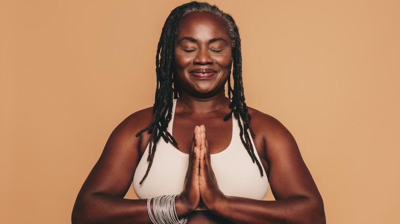 A woman meditating with joined hands