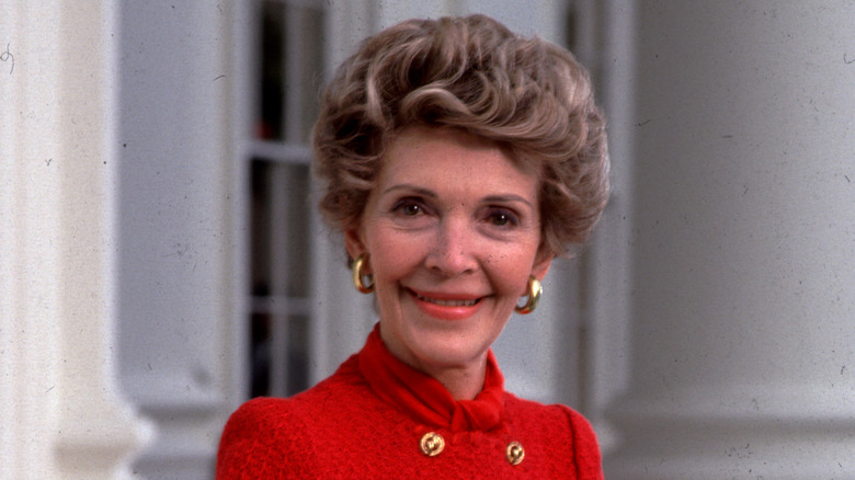 Nancy Reagan wearing red, smiling