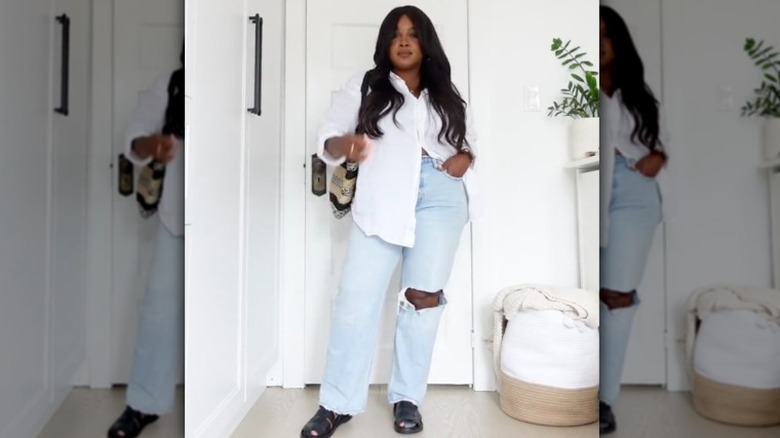 Woman wearing white shirt, jeans, and black sandals