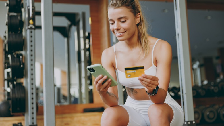 Woman looking at cell phone at the gym