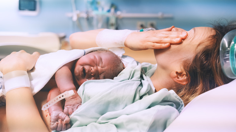 Mom hugging her newborn baby after delivery