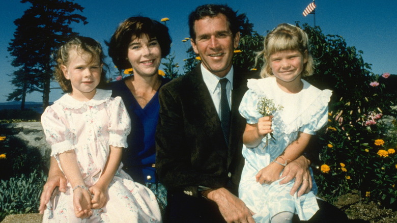 Laura and George W. Bush smiling and holding their daughters Barbara and Jenna