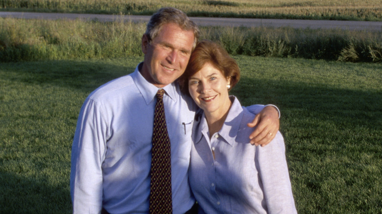 George W. Bush smiling with his arm around Laura Bush