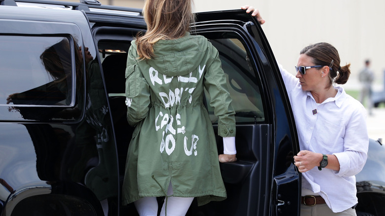 Melania Trump wearing green coat that says "I really don't care, do u?