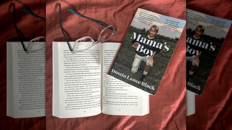 "Mama's Boy" dust wrapper next to open book 