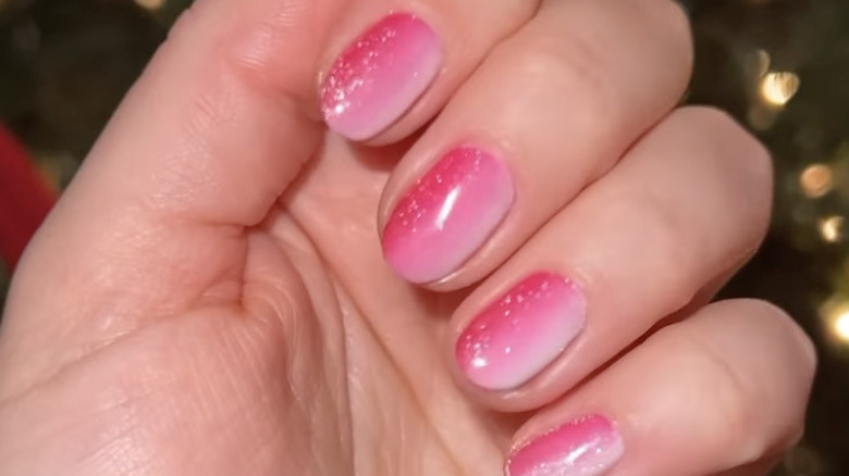 fingers with pink ombre nail polish