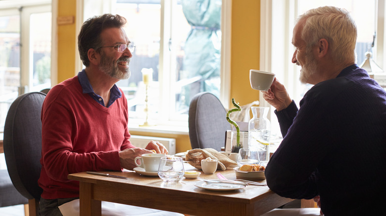 Middle aged men eating in restaurant