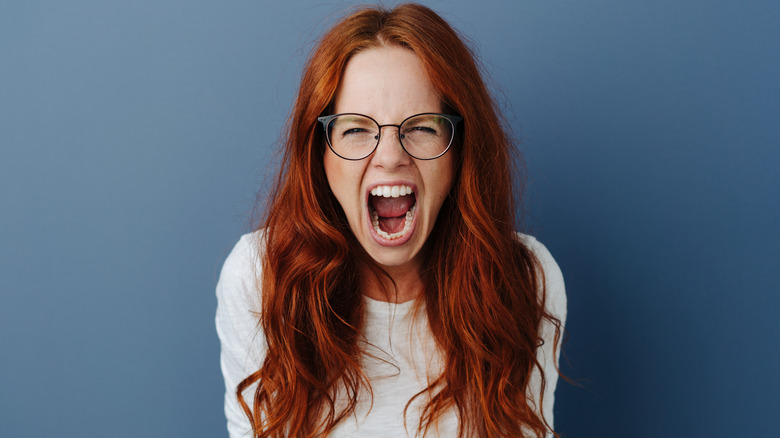 red haired woman with glasses screaming