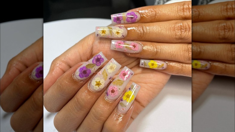 Hands showing flowery milk bath nails