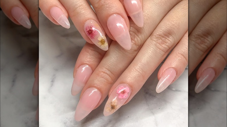 Hands showing milk bath nails with pink nude base color