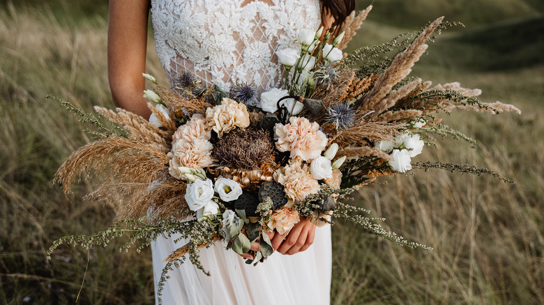 bride holding boho style wedding bouquet