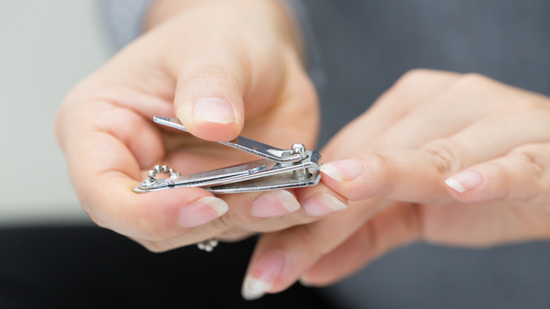 Woman clipping her fingernails