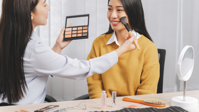 makeup artist adding blush