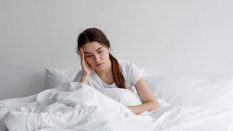 woman feeling sad in bed