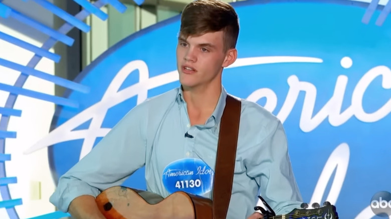 Colby Swift with guitar and audition badge