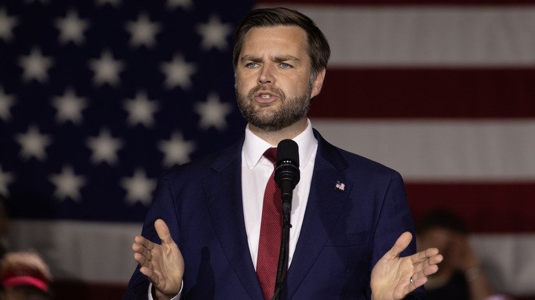 JD Vance speaking with an American flag in the background