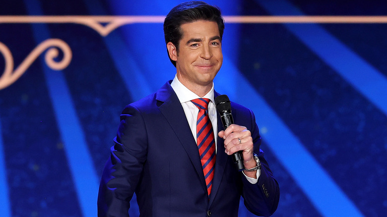 Jesse Watters speaking at an event in a suit