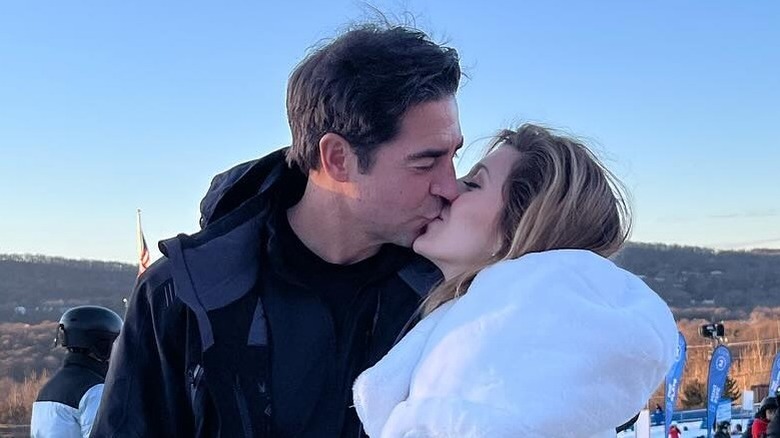 Jesse and Emma Watters kissing outside on a ski mountain