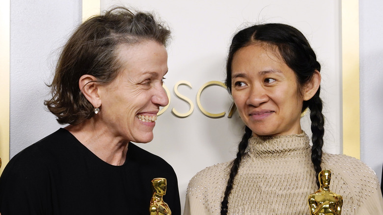 Frances McDormand and Chloe Zhao posing with Oscars