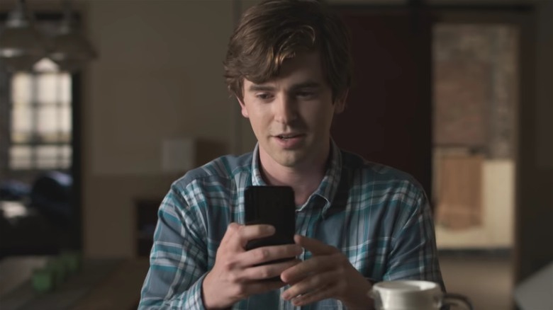 Freddie Highmore looking at phone