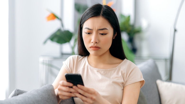 Sad woman looking at phone