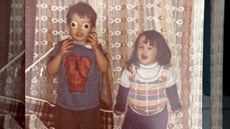 Young Rob McElhenney in spiderman shirt and goggles with his sister