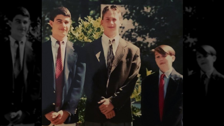 Rob McElhenney in red tie and blue blazer with two same aged high school friends