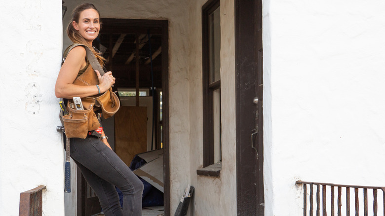 Kim Wolfe smiling in front of a house