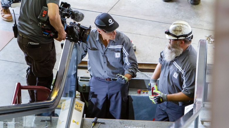 Mike Rowe fixing an escalator on Dirty Jobs