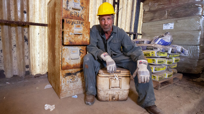 Mike Rowe sitting on a cooler