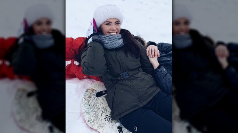 Gabi Elnicki lying in the snow smiling