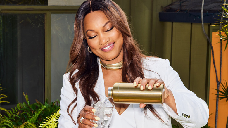 Garcelle Beauvais pouring a cocktail from a shaker