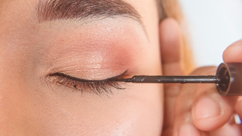 Woman applying liquid eyeliner