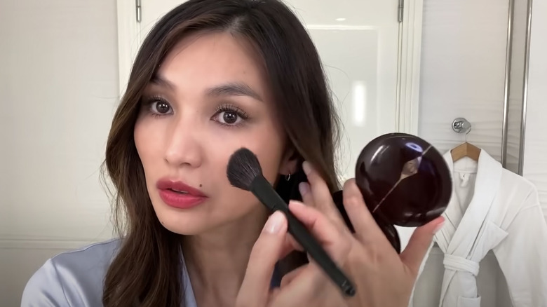 Gemma Chan applying makeup