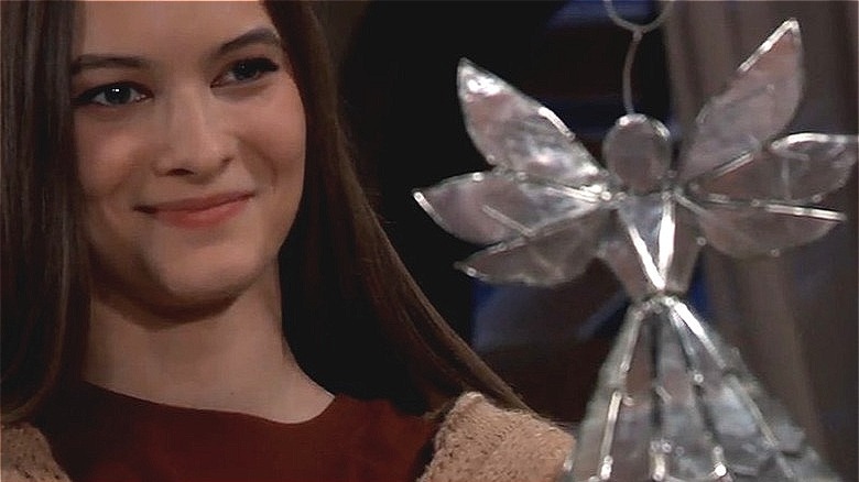 Esme holding a Christmas angel and smiling