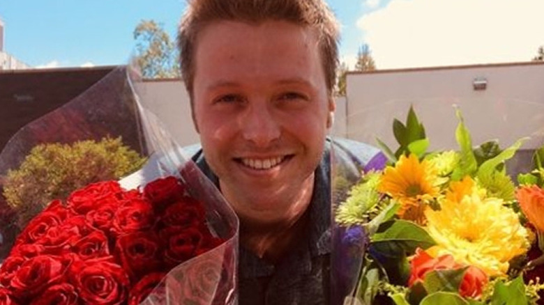 Harrison Wagner holding flowers and smiling