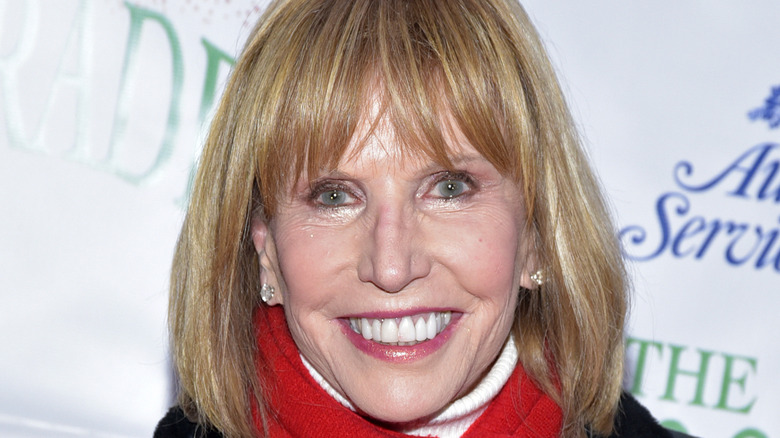 Leslie Charleson smiling in a red scarf at an event