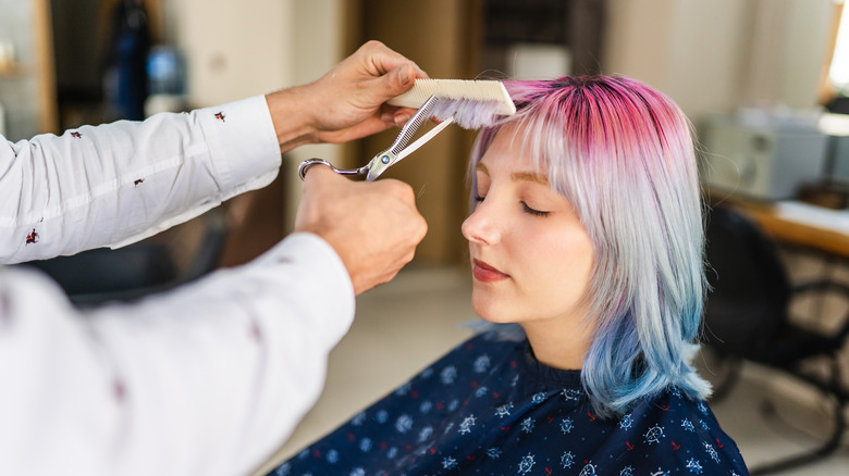 woman getting bangs trimmed 