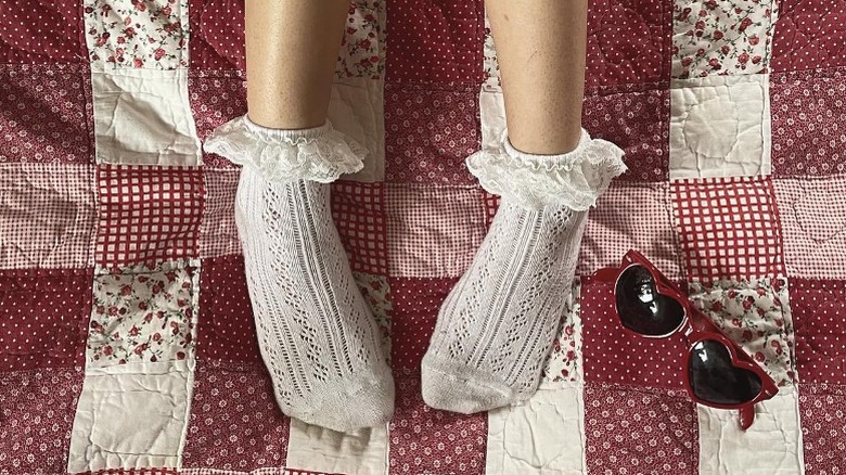 feet in frilly socks on red quilt