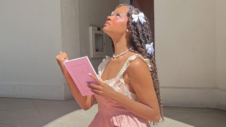 Woman holding book and wearing hair bows