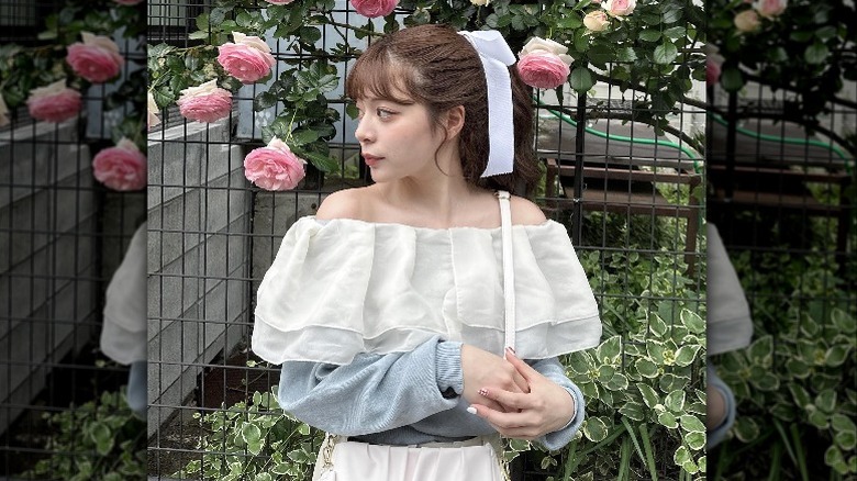 Woman in ruffled blouse and hair bow