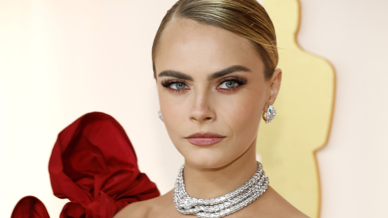 cara delevigne stud earrings, pulled back hair 