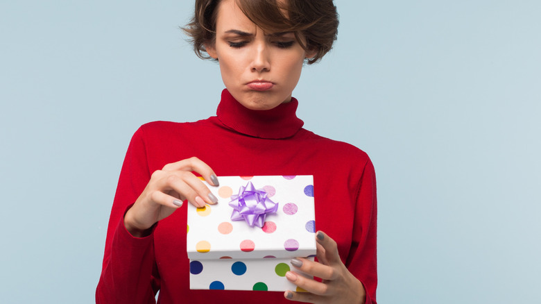 woman frowning opening gift