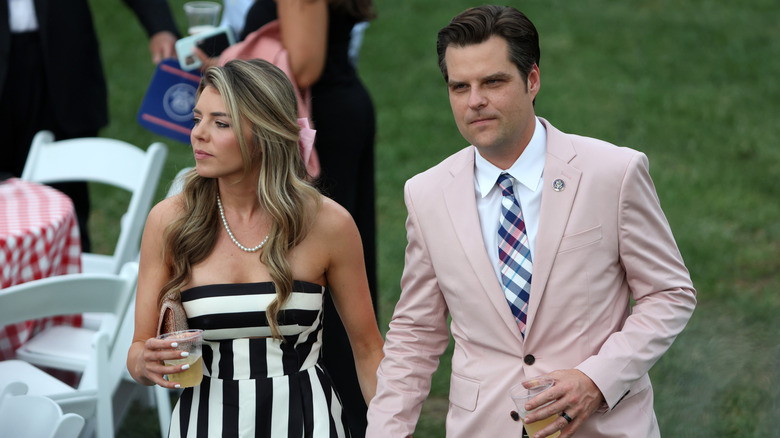 Ginger Gaetz in a black and white dress beside Matt Gaetz in a pink suit